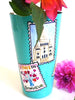 Turquoise vase with Paris landmark postcards