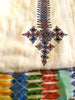 White, sleeveless traditional Ethiopian dress with multicolored cross embroidered motif