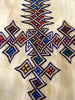 White, sleeveless traditional Ethiopian dress with multicolored cross embroidered motif