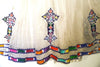 White, sleeveless traditional Ethiopian dress with multicolored cross embroidered motif